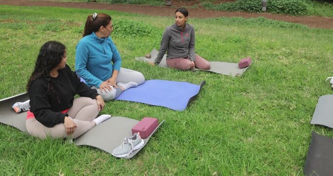 Latin women meeting together at city park for yoga class - Multi generational group, healthy lifestyle and connection concept