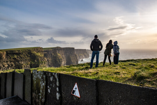 People watch the view at the Cliffs of Moher at the southwestern edge of the Burren region in Ireland.	