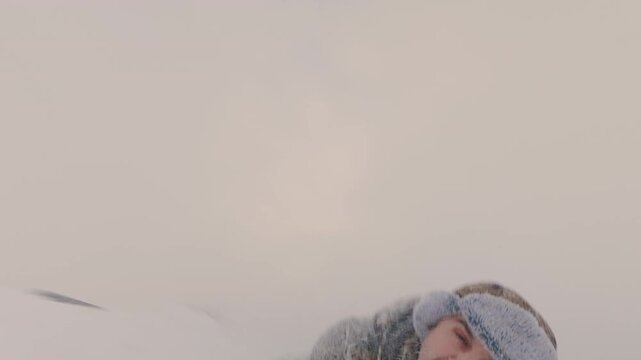 A man in winter comes to the edge of the slide and rolls down through the snow, tumbling and laughing. A guy falls down a steep hill in winter. Winter entertainment.