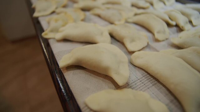 Close view of pierogi being filled by hand