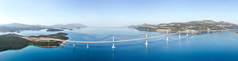 Panoramic aerial view of modern Pelje&scaron;ac Bridge spanning blue sea between islands and mainland Croatia