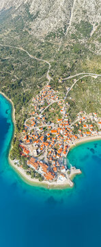 Aerial view of a small town Igrane on the Adriatic coastline. Residential buildings and a beach with clear turquoise water