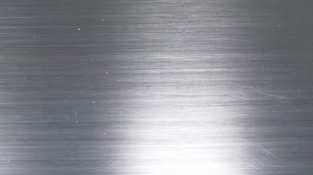 Smooth brushed metal surface with reflective highlights. Ideal for industrial design, product backgrounds, and modern aesthetics