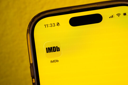 Cairo, Egypt - 27 01 2026: Mobile phone showing "IMDB" icon on a yellow background. Social media icons on the digital screen of the phone