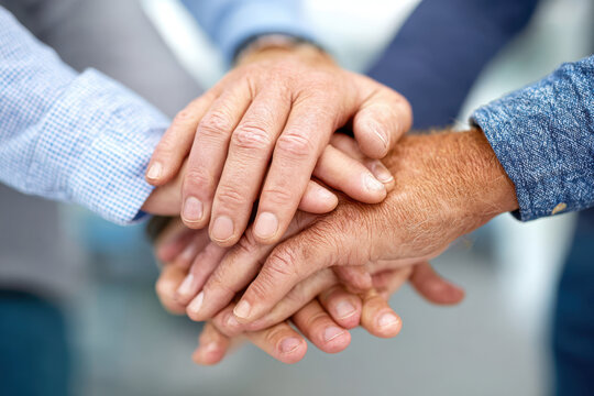 Teamwork depicted by hands stacked together in unity