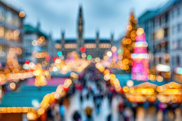 Blurry festive Christmas market with twinkling lights and tall Christmas tree