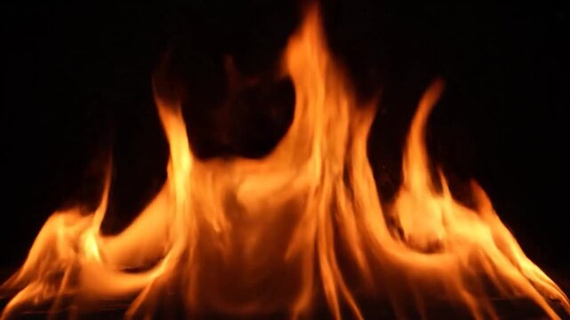 A fiery blaze dances, its orange and yellow hues against a pitch-black backdrop