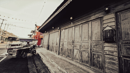 Old wooden shop houses along street, vintage urban scene, traditional architecture and nostalgic old town atmosphere.