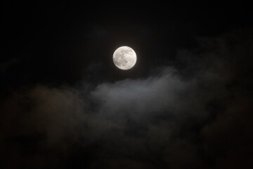 full moon on dark sky with clouds