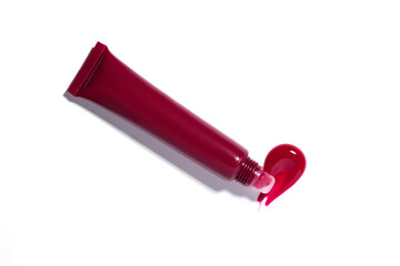 Vivid red lip gloss smear next to a cosmetic tube applicator on white