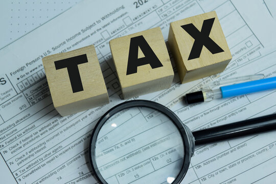 Concept of text TAX on wooden blocks. Indian income tax return document
