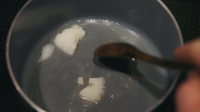 Melting Coconut Oil In Pan, Wooden Spoon Nudging White Solid Into Glossy Liquid, Gentle Sizzle And Clear Heat, Vegan Friendly