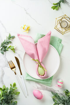 Easter table setting on white background with spring decorations.