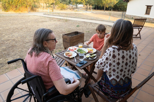 Family generations eating meal together outdoors