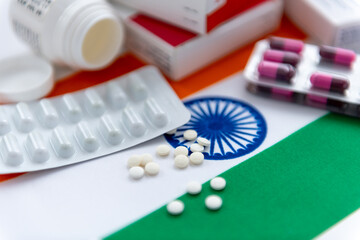 A close up of various loose and package medicine on the national flag of India. An Indian medical,...