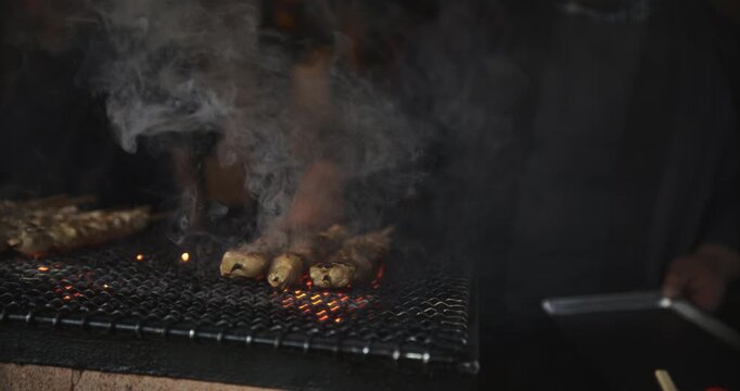 Delicious dumpling kebabs being grilled - panning shot