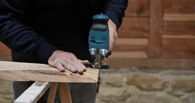A skilled craftsman uses a professional hand saw and carpentry tools to perform precision wood cutting for a construction worker job in the industry