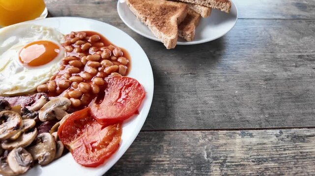 Full English breakfast with fried egg, bacon, sausages and beans