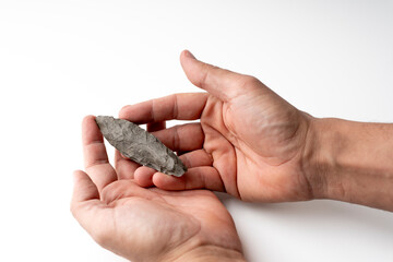 Obraz premium Pov camera. Ancient Paleolithic Flint Spear | Prehistoric Biface Tool from Algerian Sahara. my hand. white bakcround