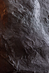 Textured dark surface with intricate patterns and natural variations