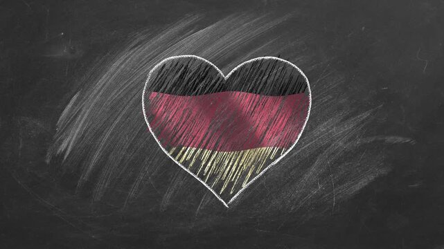 National flag of Germany in heart shape  drawn with colored chalk on a blackboard. German language, Learning German.