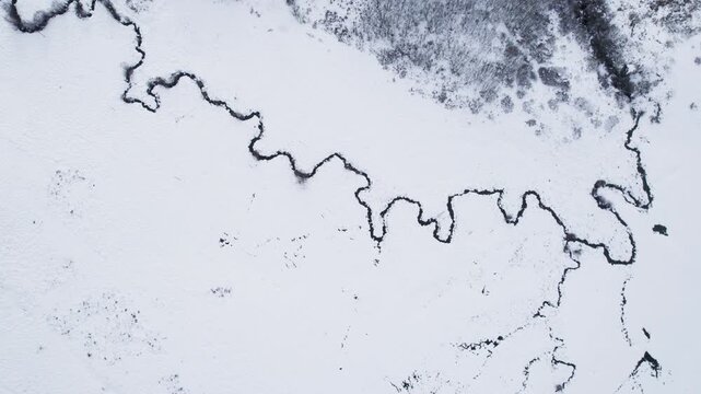 Drone shot of meandering stream in frozen landscape The Concept of Natural Contrast