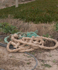 Abandoned fishing ropes on sandy beach, marine pollution and environmental concept