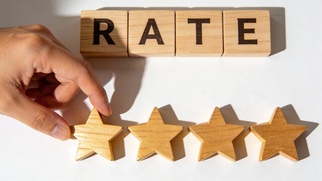 Hand Setting Four Star Rating with Wooden Blocks Spelling RATE