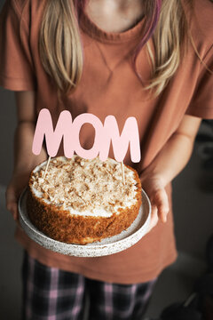 Happy mothers day concept with celebrate homemade cake with mom text holding kids hands