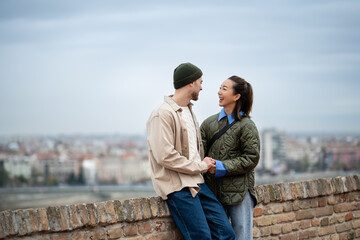 Happy couple traveling, laughing together overlooking city view