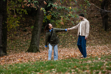 Fototapeta premium Happy couple holding hands walking in autumn park