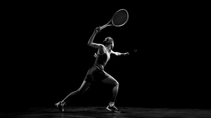 Female tennis player performing powerful forehand stroke in dark studio. Concept of professional sport training, strength, focus, competition, athletic performance and dynamic monochrome. © master1305