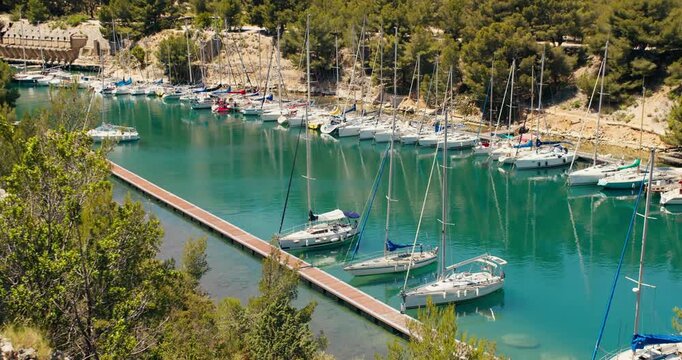 Narrow fjord-like calanque with moored boats in Port-Miou near Cassis. Natural harbor with turquoise water and rocky Mediterranean landscape