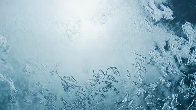 Frozen ice patterns creating a cold, textured background, showing intricate frost formations on a shimmering blue and white surface, conveying winter concepts