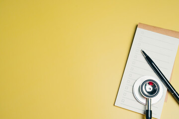 Medical concept. Medical checklist with stethoscope and pen on yellow background, symbolizing...