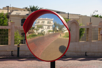 A round road mirror on a sunny day.