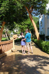 man and a woman at a resort hug while standing.