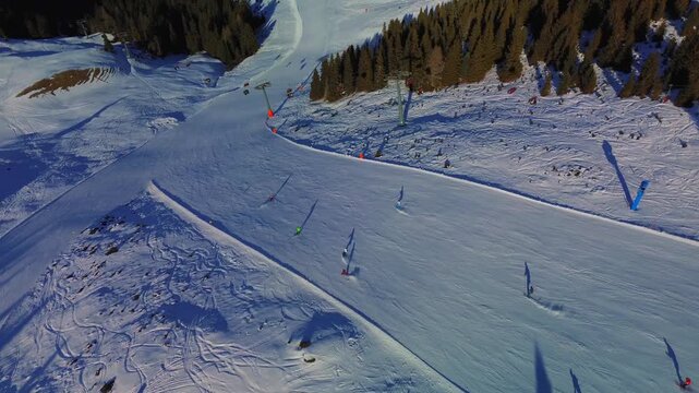 Aerial view of the Seiser Alm snowpark. Freestyle ski jumps with the Seiser Alm logo are seen against the backdrop of vast snow-covered plateaus and distant mountain peaks. Alpe di Siusi, Italy