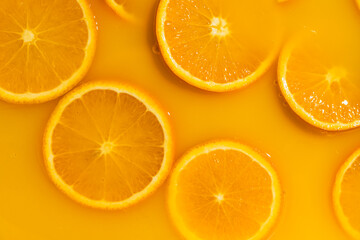 Orange slices swimming in fresh orange juice, horizontal macro.