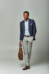 Stylish young man expresses confidence with a fashionable outfit and a leather bag