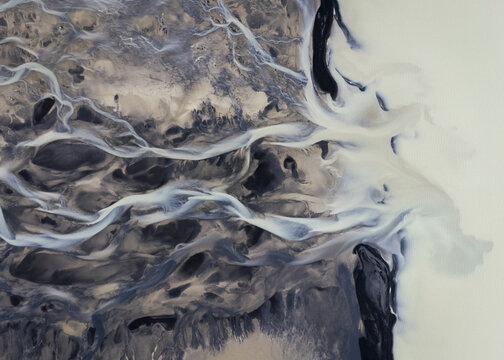 Aerial view of glacial rivers carving paths through varied terrain, creating striking patterns and contrasts in the Icelandic landscape, Selfoss, Sveitarfelagid Arborg, Iceland.
