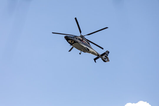 Helic&oacute;ptero voando sob um c&eacute;u azul. 