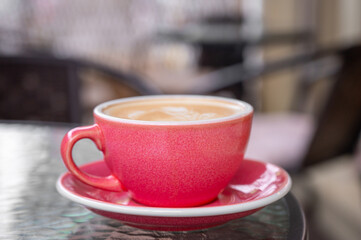 Fototapeta premium a pink cup of coffee on a summer terrace. copy space
