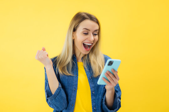 Surprised young lady using mobile phone with shock. woman holding smartphone enjoy and fun relax time