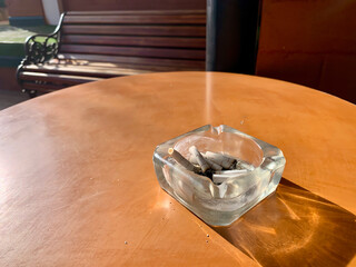 The cigarette butt was placed on the glass tray.