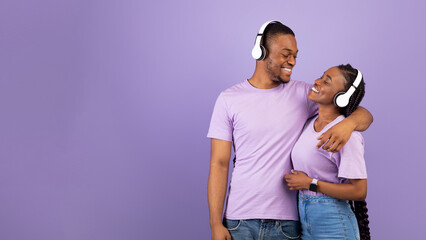 Favourite Playlist. Portrait of positive black couple enjoying music in wireless headphones, guy...