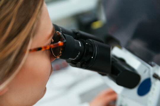 Close-up of woman using microscope