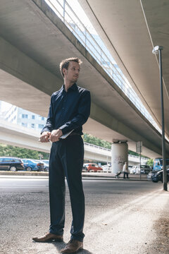 Businessman standing at underpass holding laptop