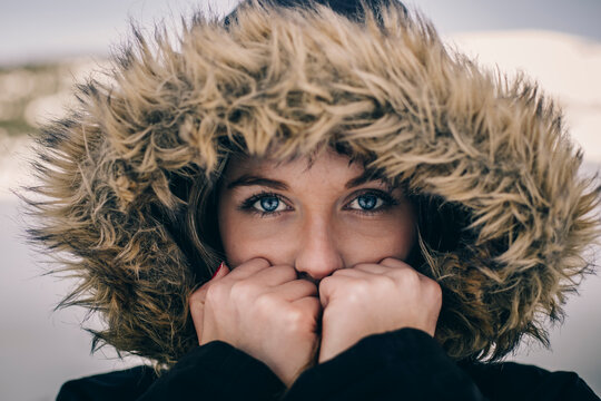 Portrait of young woman wearing hood in winter