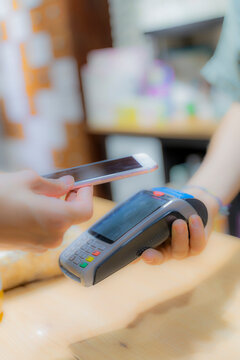 Customer paying cashless with smartphone in a shop